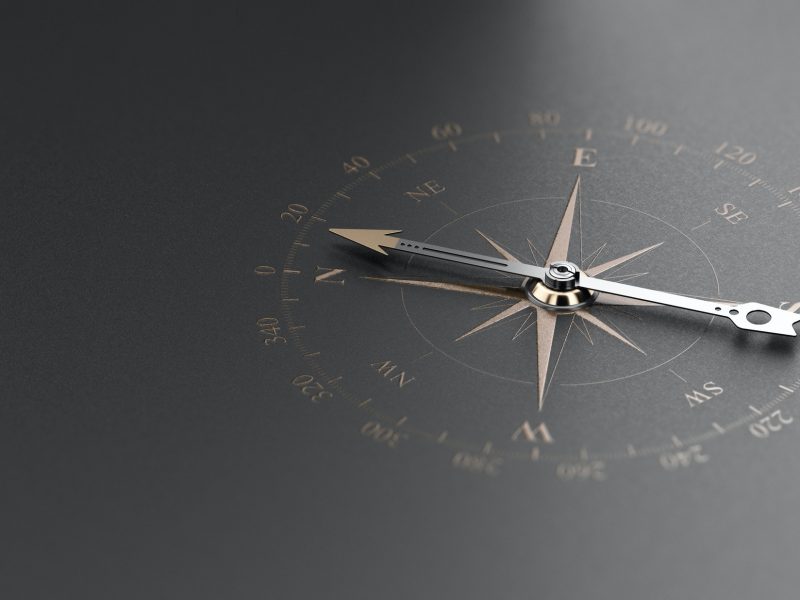 Business Guidance Or Orientation Concept. Compass over Black Background