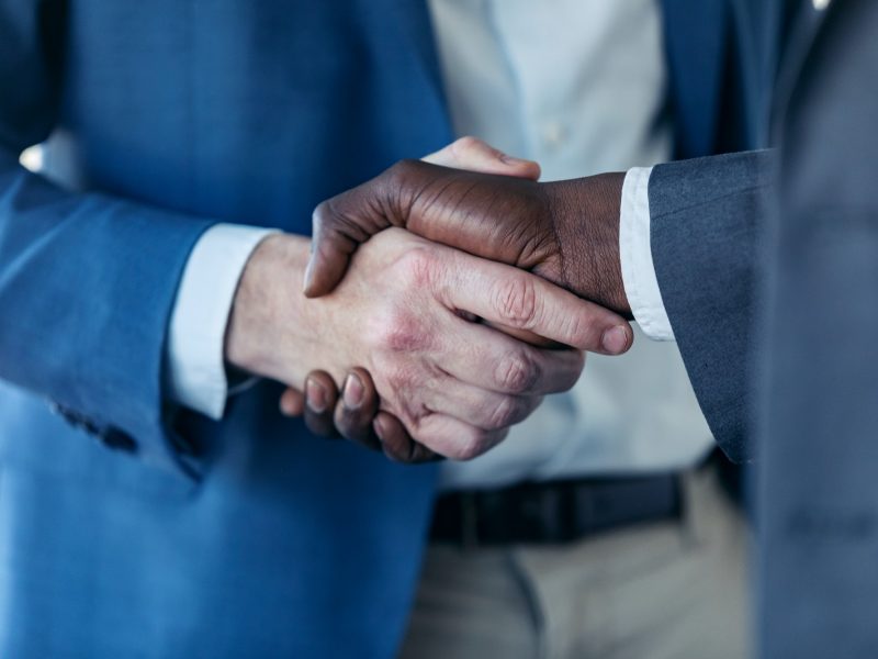 Close-up view of business partner handshaking process.