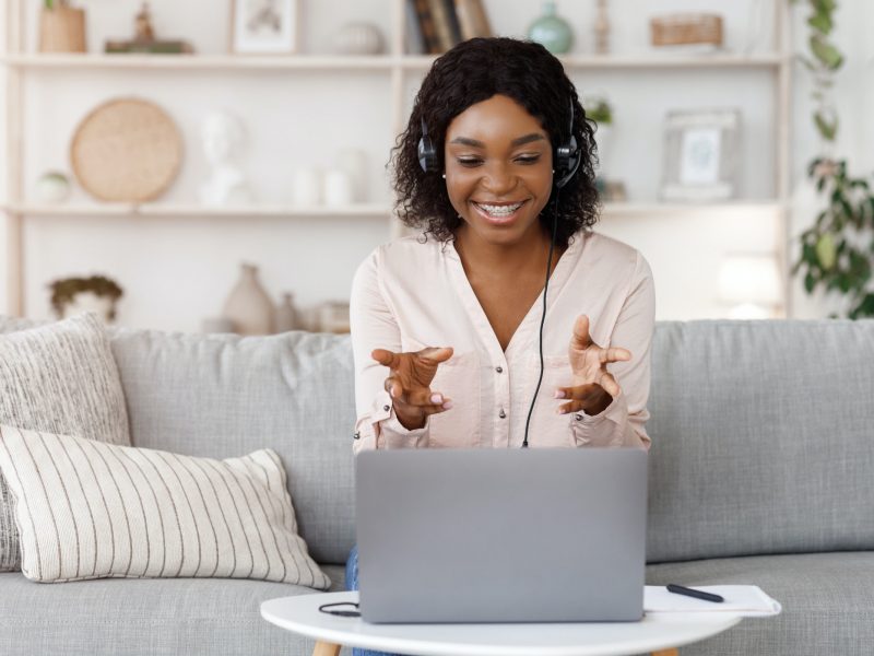 Online Tutoring Concept. Smiling black female tutor having video call with student