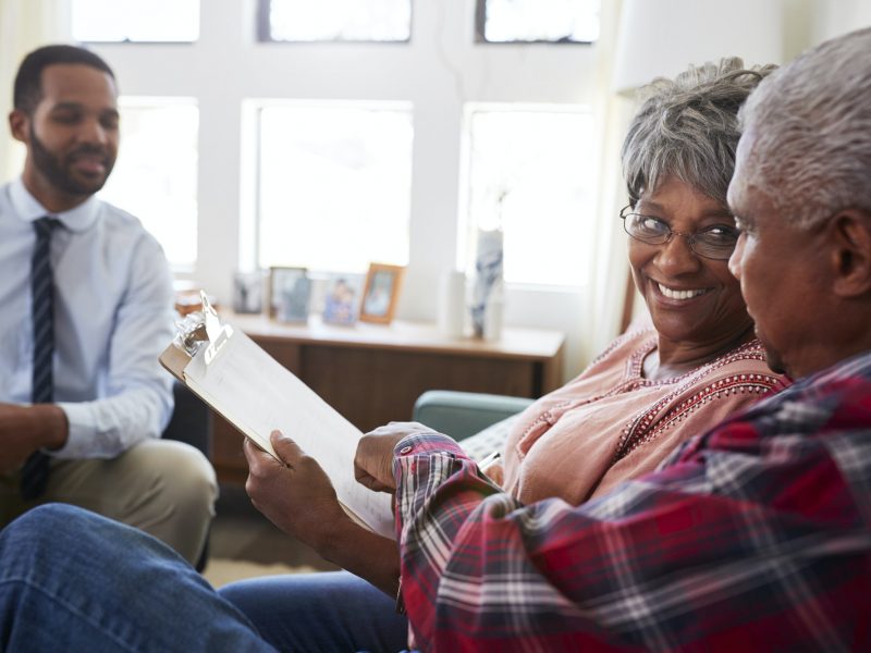 Senior Couple Meeting With Male Financial Advisor At Home