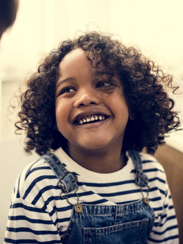 Young cheerful black kid with family